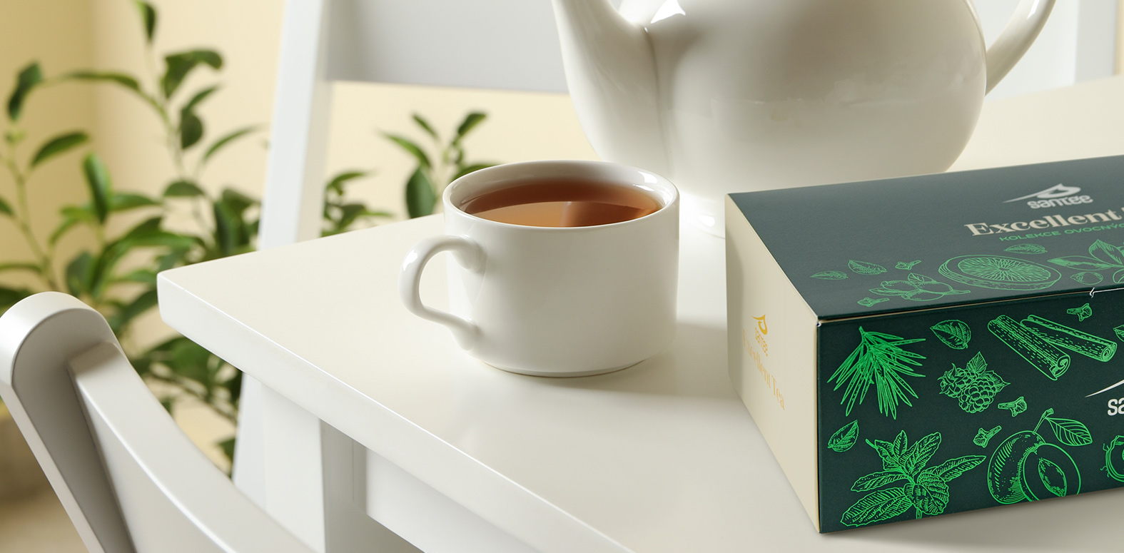 Návrh obalu dárkové kolekce čajů na stole se šálkem v reálném prostředí.